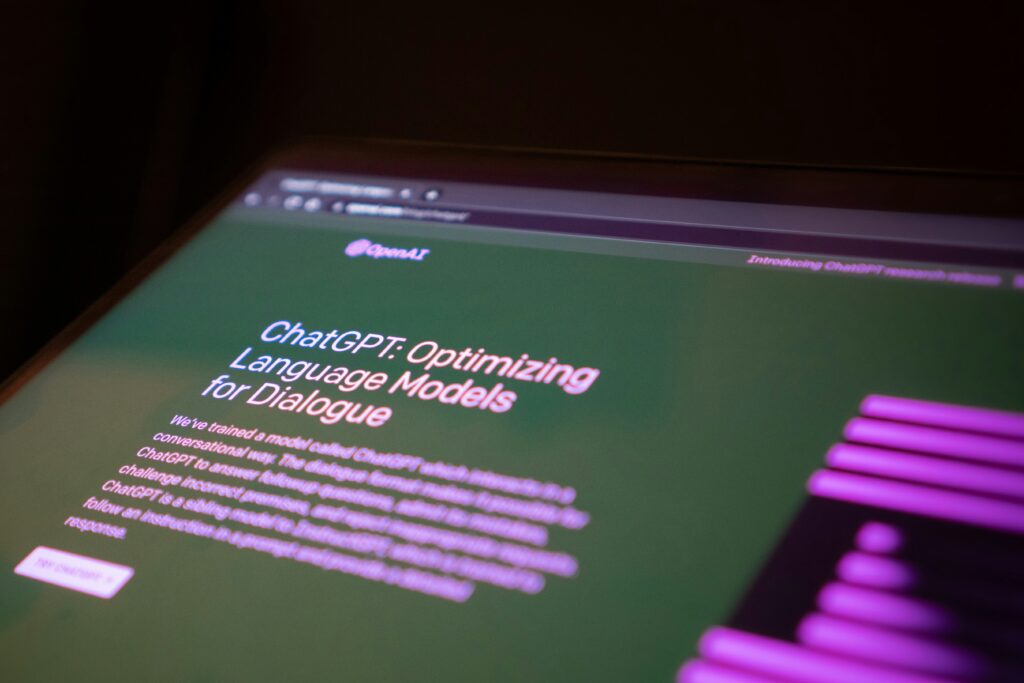 A close-up of a computer screen displaying the ChatGPT interface with the text "Optimizing Language Models for Dialogue" from OpenAI.