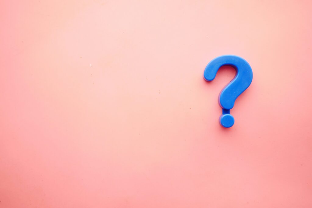 A large blue question mark on a pastel pink background, symbolizing curiosity and the search for answers.