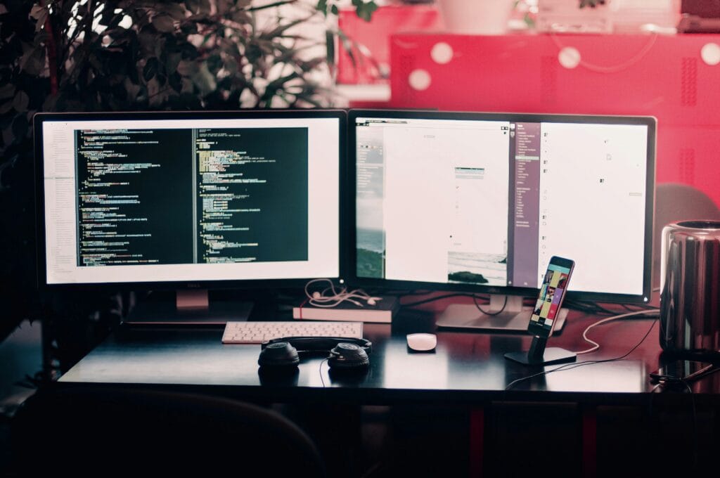 Multiple computer screens showing security monitoring tools