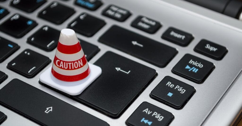 Miniature caution cone on a computer keyboard symbolizing data security and control.