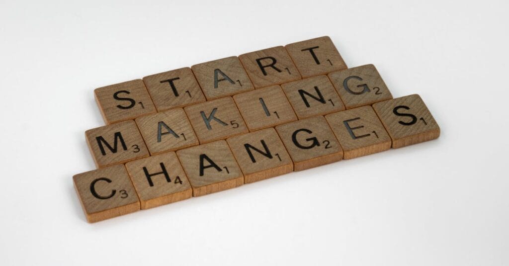 Scrabble tiles on a white surface spelling 'Start Making Changes'.